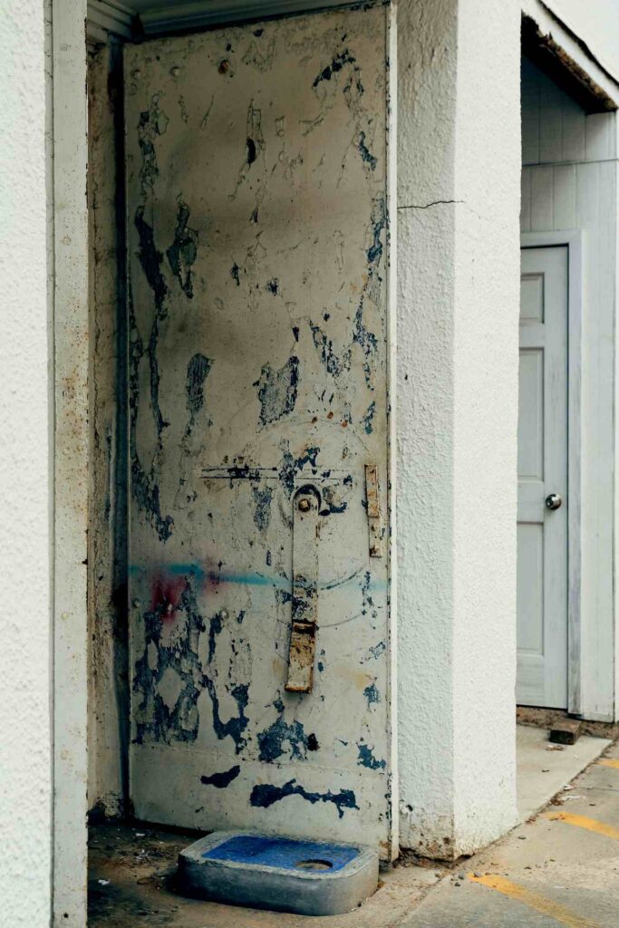 A paint-faded metal doorway to a store in a Ruston, Louisiana alley.